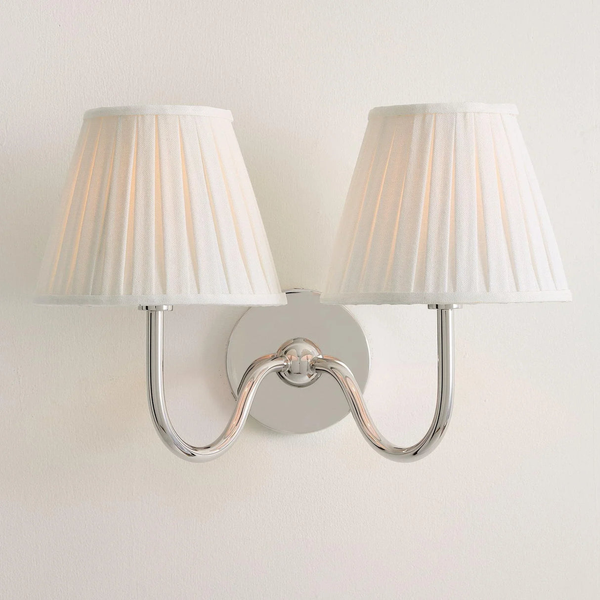 Rustic pleated fabric wall sconce with curved metal arm and round backplate, white shade front view 31