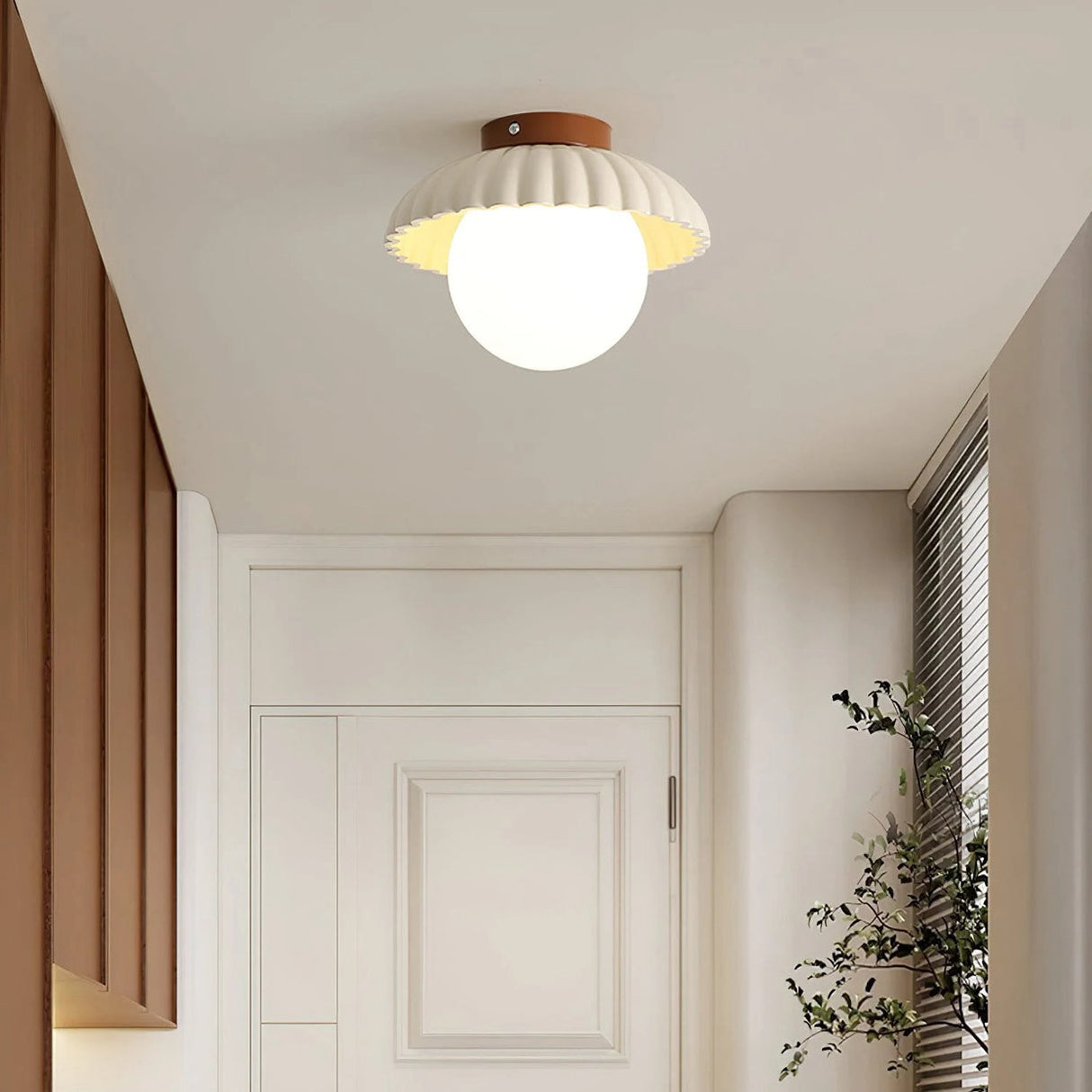 Front view of the scalloped shade ceiling light with frosted glass globe