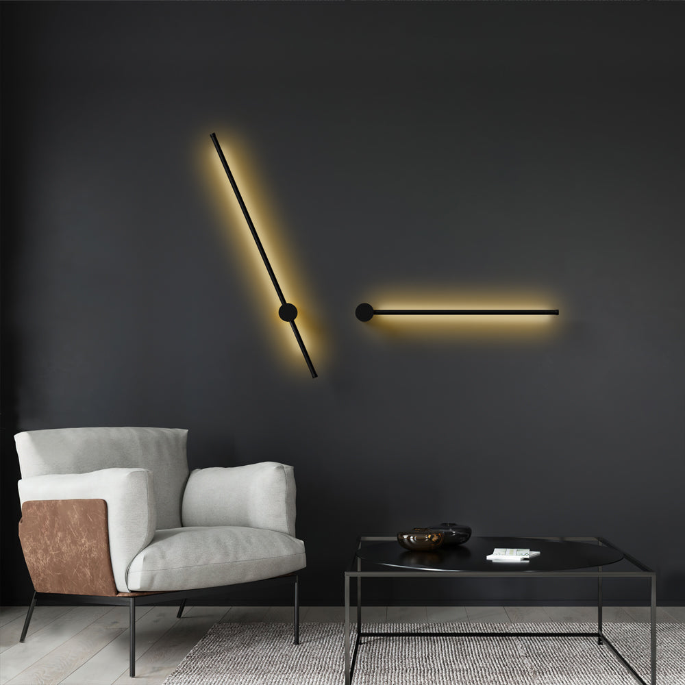 Two angled black wall lights on a charcoal wall above an armchair
