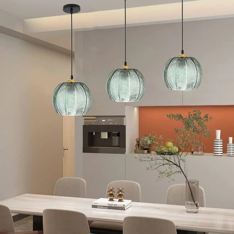Modern bohemian living room lit by a green textured glass globe pendant light