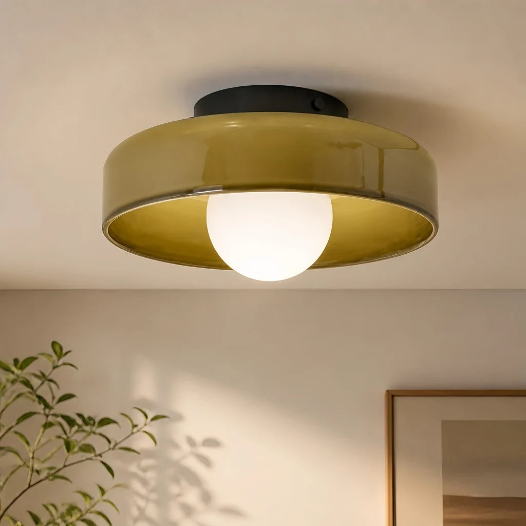 Olive glass disc light shown against a plain background