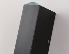 Top corner detail of the matte black aluminium sconce body on a pale wall