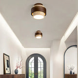 Yellow travertine ceiling light with dark walnut banding in soft light