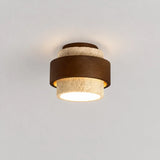 Cylindrical travertine and wood ceiling fixture photographed from above angle