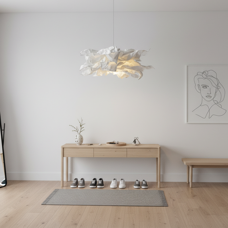 Paper pendant light above a slim console table in a plain white hallway