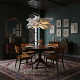 Paper pendant light over a round table in a dark green panelled dining room