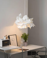 Paper pendant light over a desk with a framed print and a small speaker