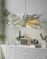Close view of the lit paper shade above a table with candles and a clock