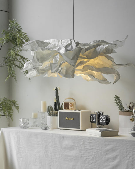 Close view of the lit paper shade above a table with candles and a clock