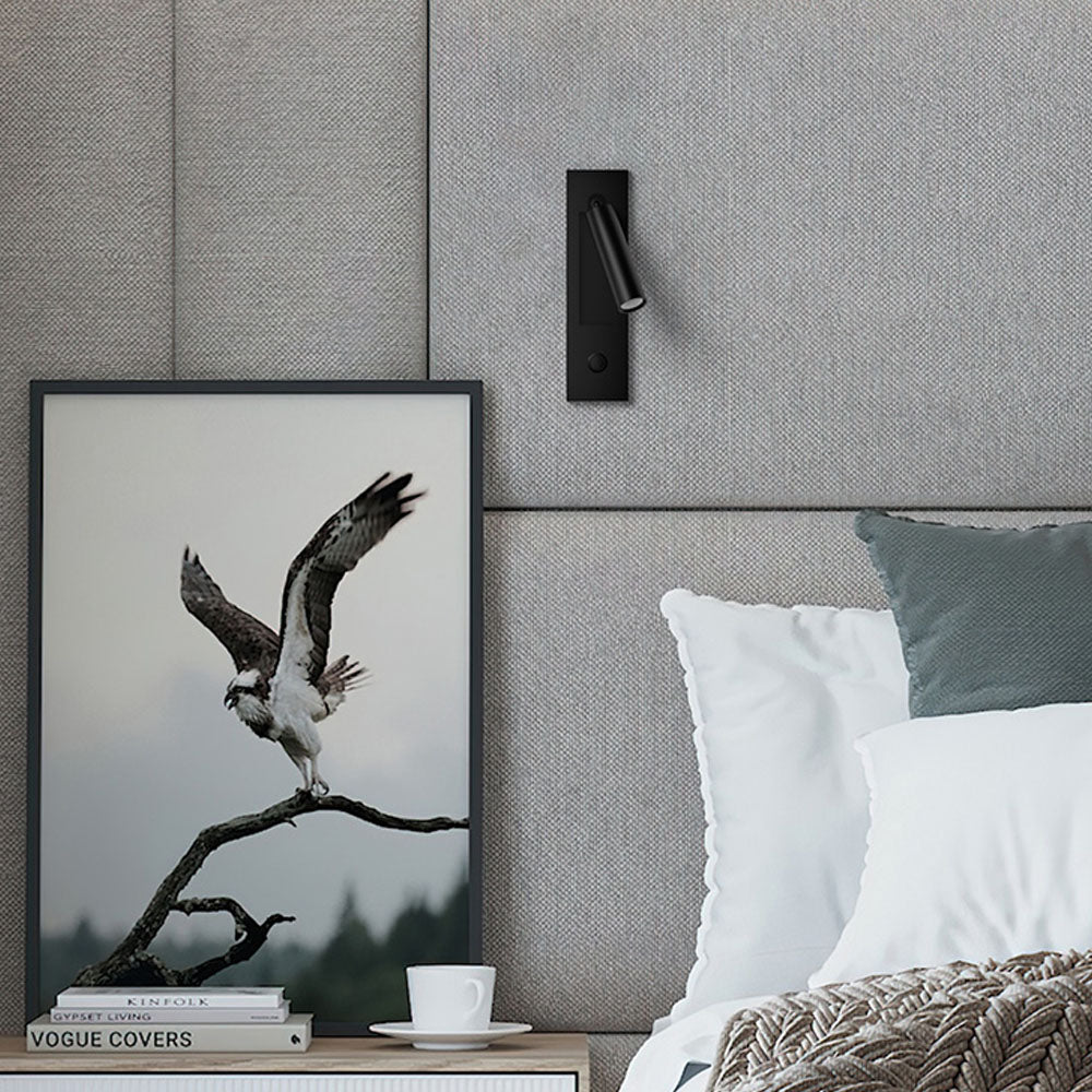 Reading wall light with book, glasses and glass of water on the nightstand