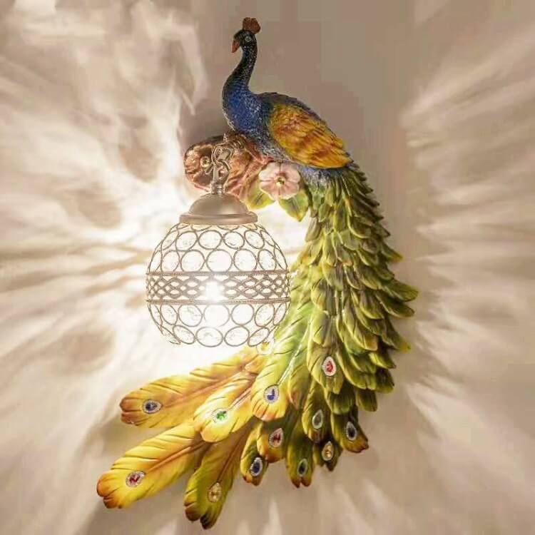 Green and blue peacock wall sconce lit warmly with crystal ball shade at left