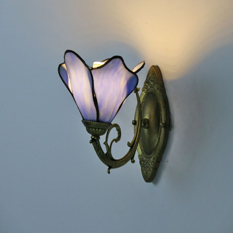 Stained glass petal wall sconce shown from the front on a bronze fixture