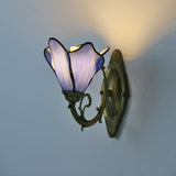 Stained glass petal wall sconce shown from the front on a bronze fixture