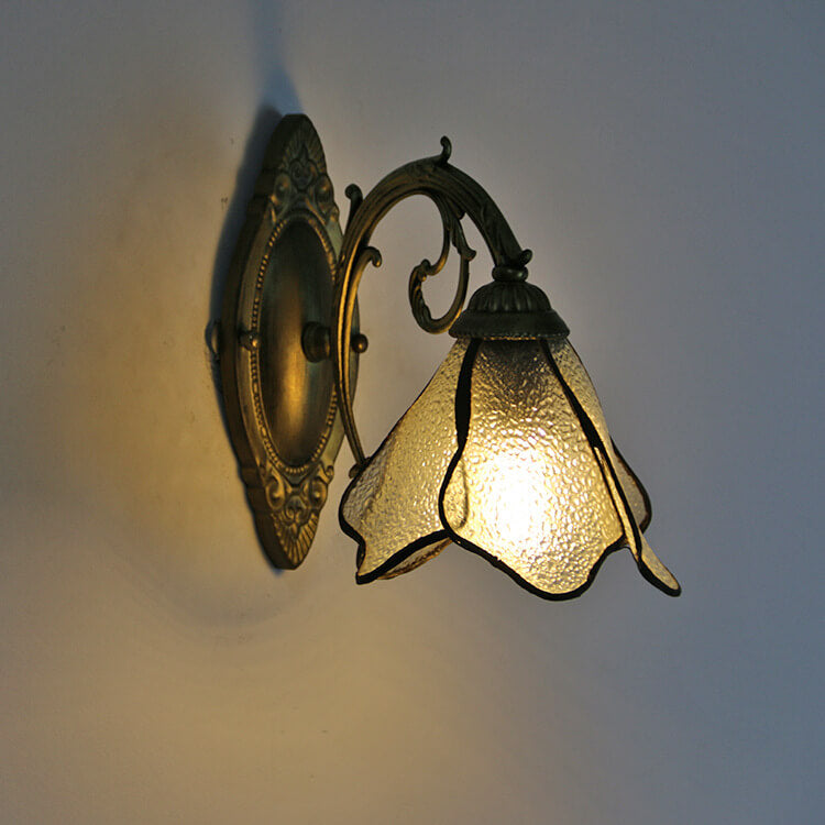 Antique bronze oval backplate and scrolled arm of the wall sconce