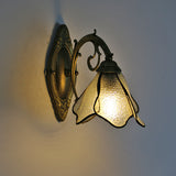 Antique bronze oval backplate and scrolled arm of the wall sconce