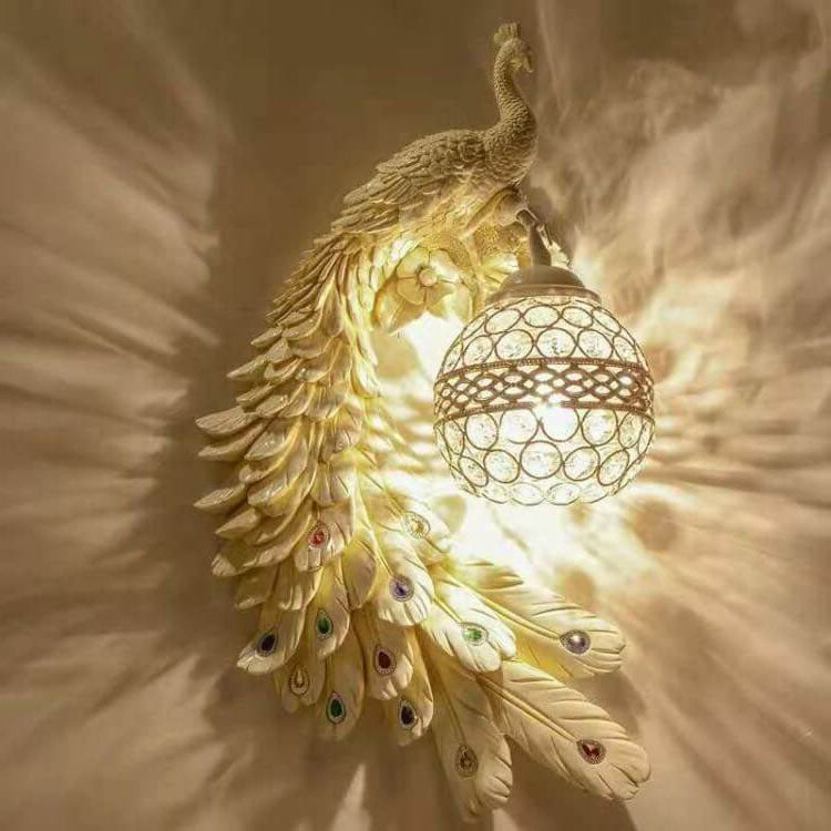 Blue teal peacock wall sconce with a gold crystal ball shade on a plain wall