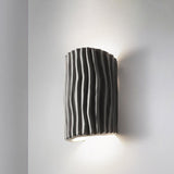 Gray striped resin wall sconce product shot on a light wall