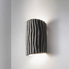 Gray striped resin wall sconce product shot on a light wall