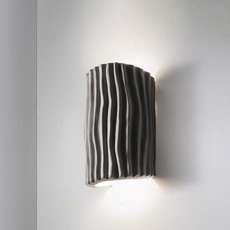 Gray striped resin wall sconce product shot on a light wall
