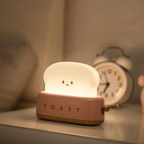 Green toaster novelty lamp lit on a plain background