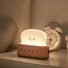 Green toaster novelty lamp lit on a plain background