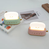 Warm white toaster lamp lighting a dark desk corner
