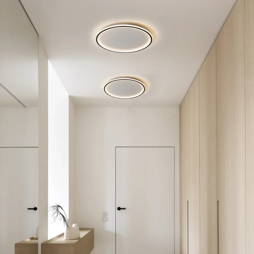 White round ceiling light glowing softly in a neutral room