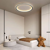 Black round LED ceiling light casting soft light in a bedroom