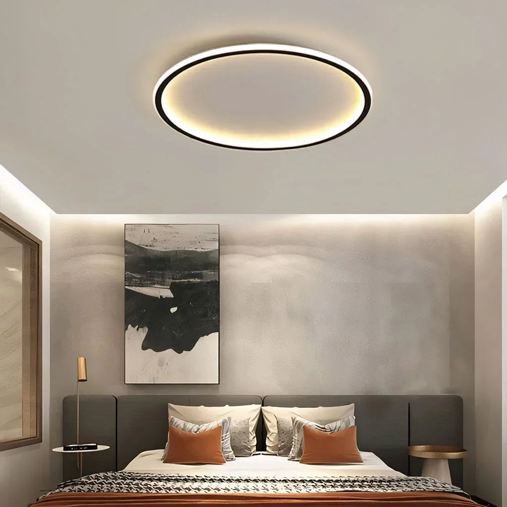 Black round ceiling light with warm ambient glow in a calm bedroom