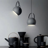 Blue ball pendant light tilted downward to show its lit open face