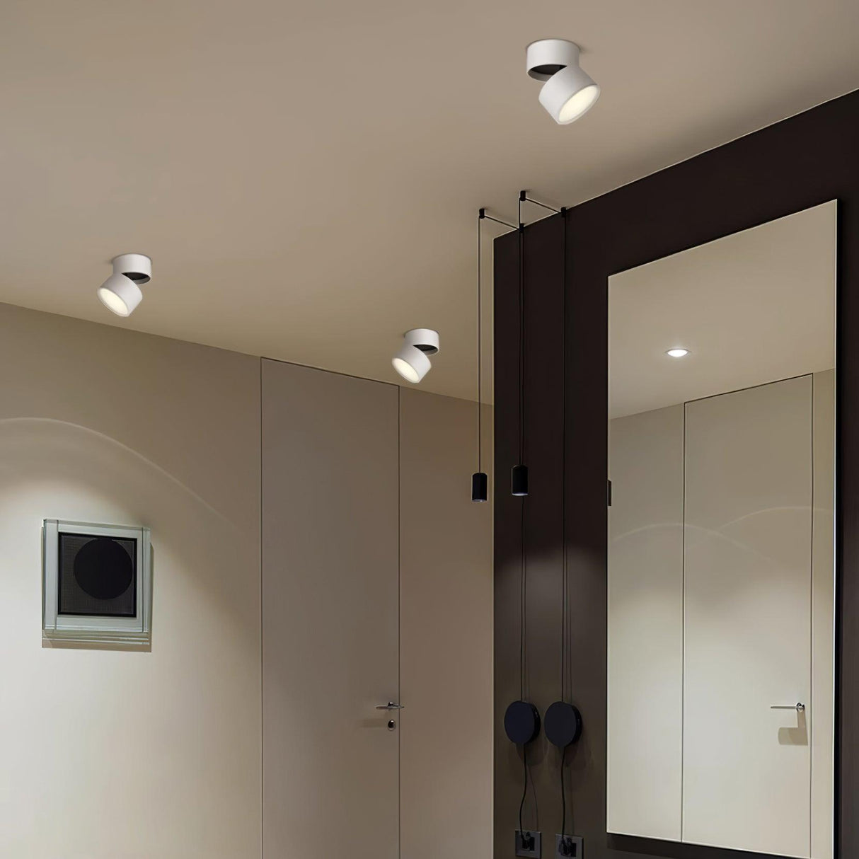 White adjustable spot lights angled along a curved hallway beside a mirror
