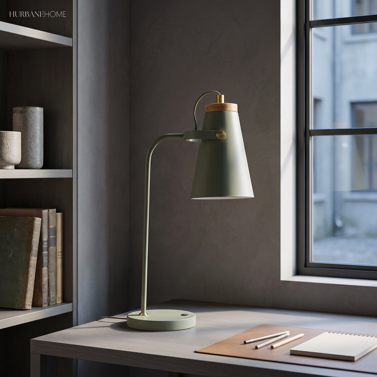 Sage desk task light beside a window and open notebook on a desk
