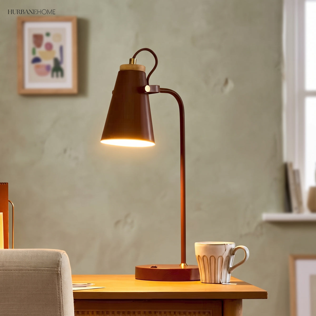 Rust brown desk lamp glowing warmly on a desk beside a mug