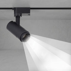 Black tubular track spotlight aimed down casting a focused beam