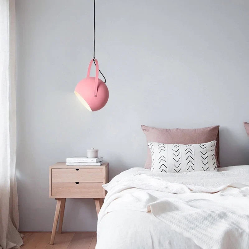 Adjustable ball metal pendant light tilted to aim its spotlight beam