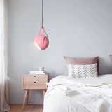 Adjustable ball metal pendant light tilted to aim its spotlight beam