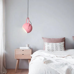 Adjustable ball metal pendant light tilted to aim its spotlight beam