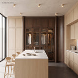 Ceiling downlights above a pale kitchen island and glazed wardrobe joinery