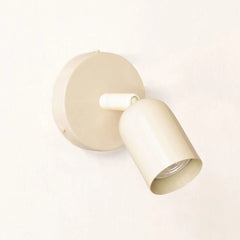 Beige spotlight wall sconce angled view with the head turned down and right