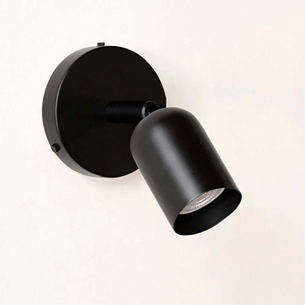 Black spotlight wall sconce angled view with the head turned down and right