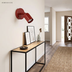 Red spotlight wall sconce above a console table in an entryway hallway