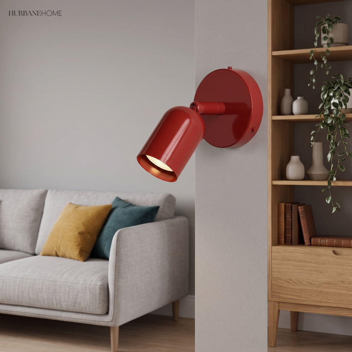 Red spotlight wall sconce on a living room wall beside a sofa and shelving