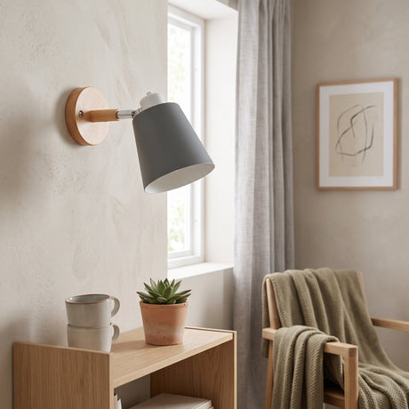 Grey shade sconce tilted on a wall above a timber desk