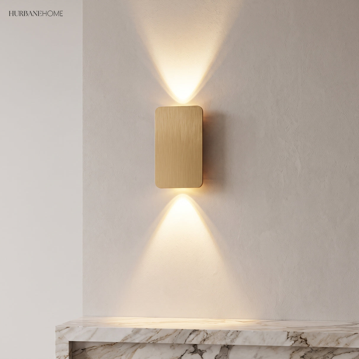 Gold aluminium wall sconce washing a plaster wall above a marble console