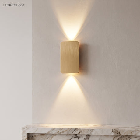 Gold aluminium wall sconce washing a plaster wall above a marble console