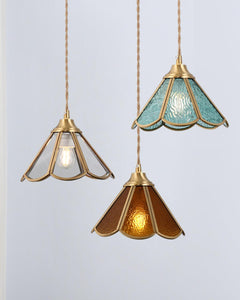 An amber and a blue glass pendant hung together at different drop heights