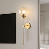 Amber glass globe wall sconce on a brass stem front view