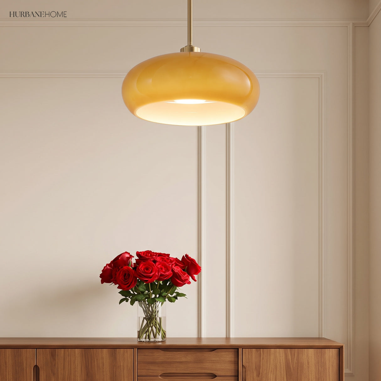 Amber glass pendant hanging on a copper rod above a wooden console with roses