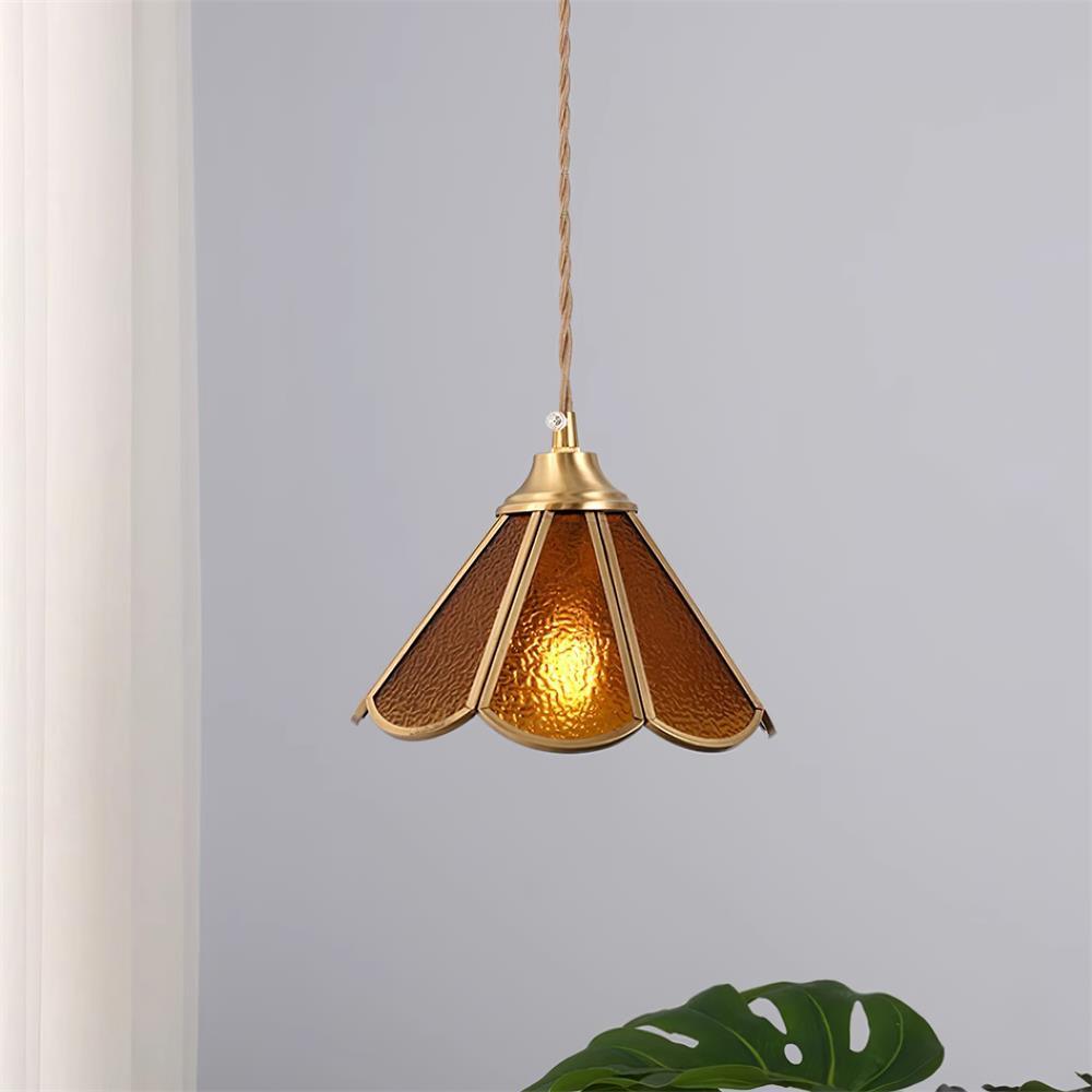 Amber glass pendant lit beside a curtain, showing the glow through the panels