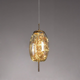 Oval amber glass shade lit by a starry LED cluster on a brass stem